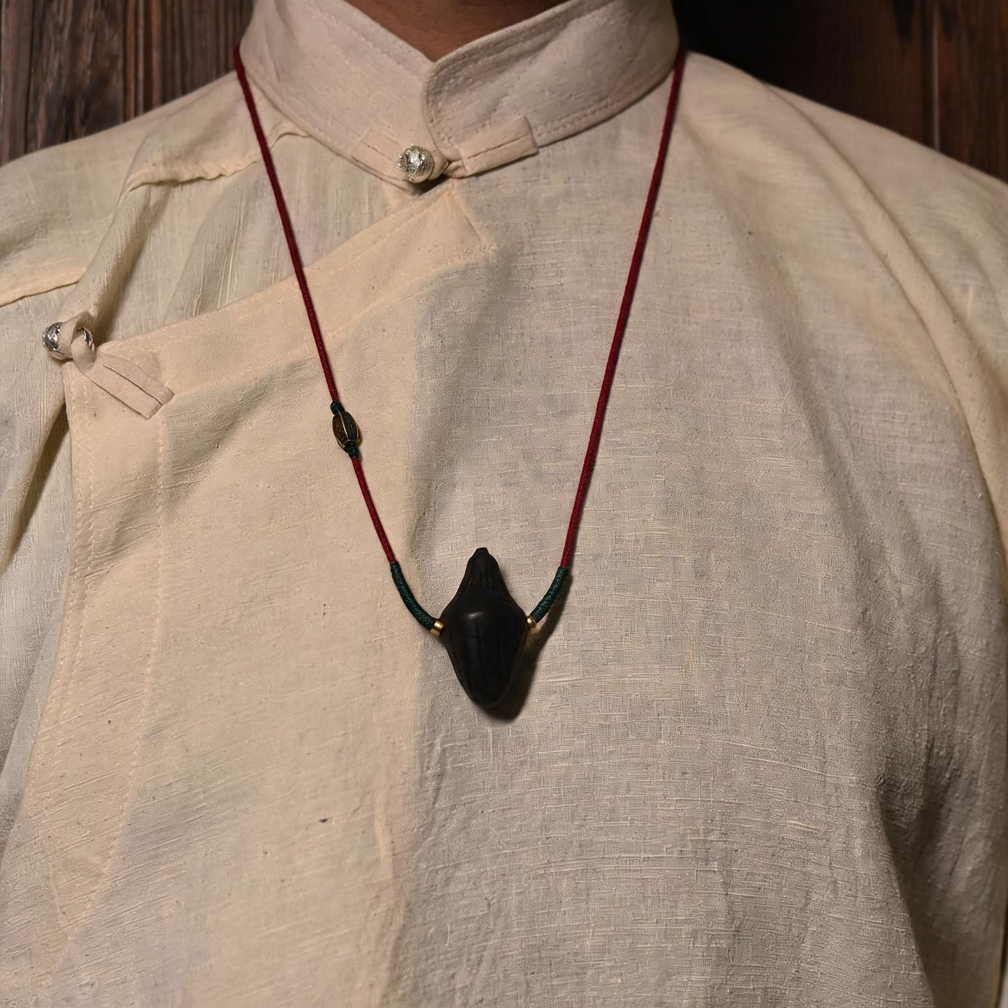 Model wearing black Nyangla tsatsa pendant necklace