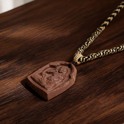 Milarepa arch-shaped brown clay tsatsa pendant necklace flat lay