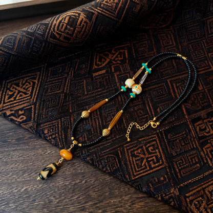 Kumbu tiger tooth dzi bead amber necklace main flat lay