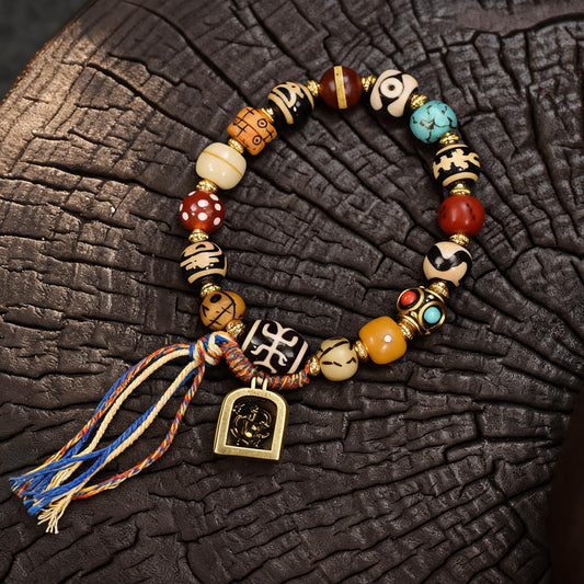 Tibetan dzi bone multi-treasure bracelet with gau box tassel main flat lay