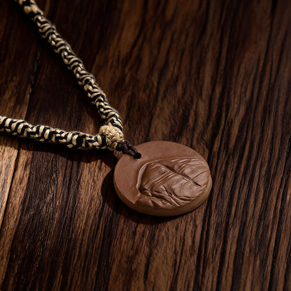 Close-up of Mount Kailash mountain relief on brown clay pendant