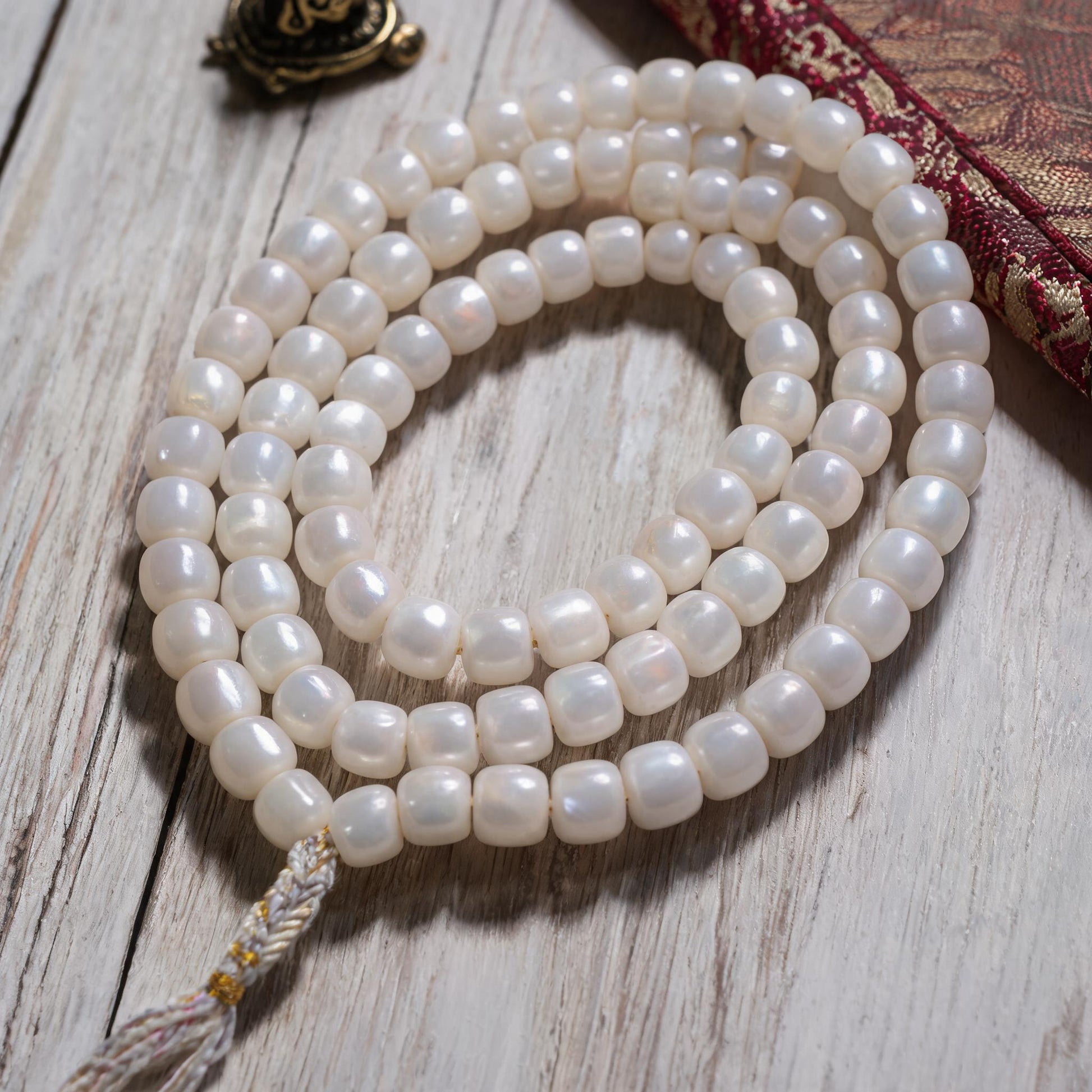 Handcrafted Mother-of-Pearl 108 & 27-Bead Mala Collection - Light of the Snowlands · 8×7 mm · 108 Beads · White-Gold Tassel - material and construction detail