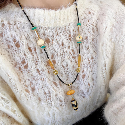 Kumbu dzi bead pendant worn close-up detail