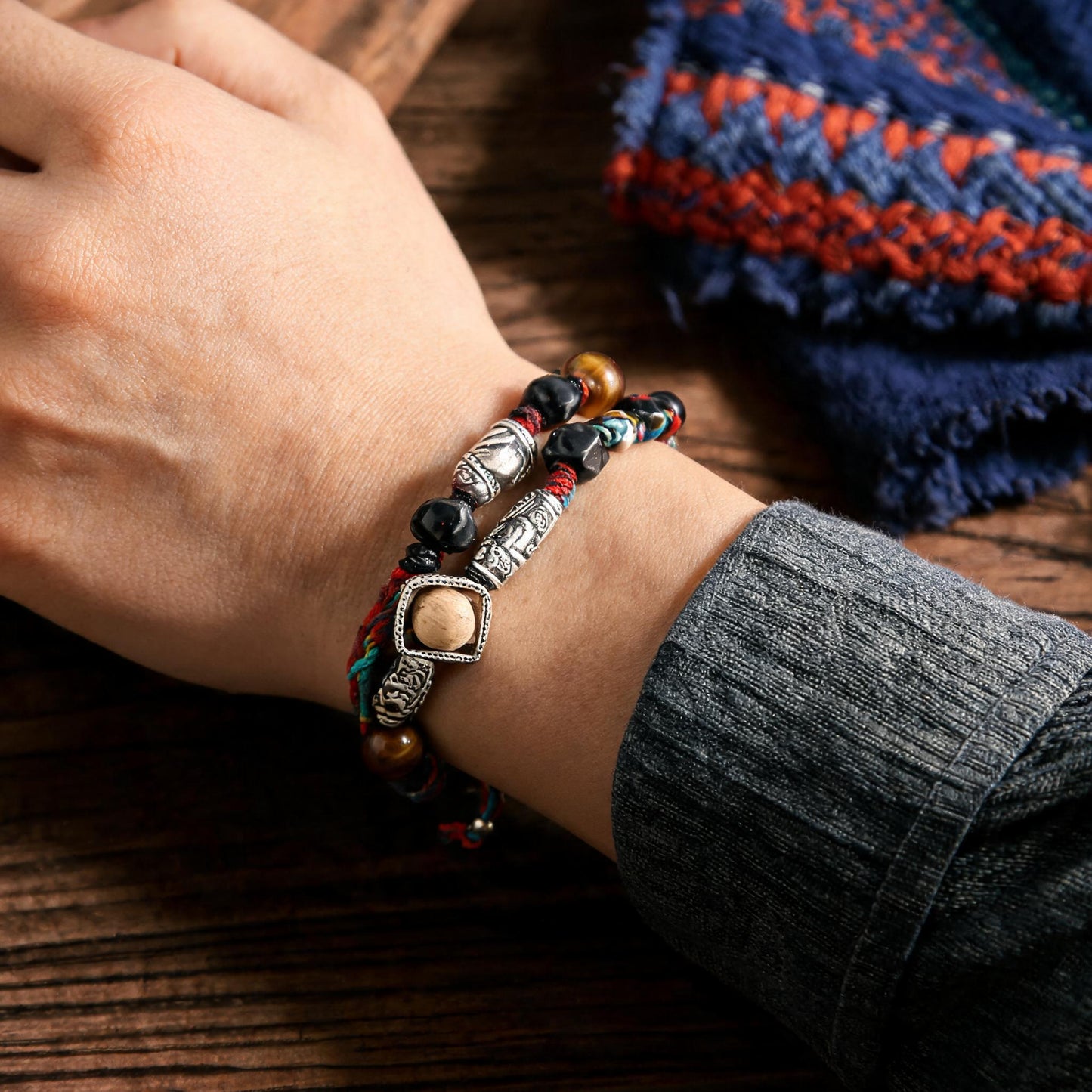 Hand-woven multicolor cord bracelet worn on wrist for scale