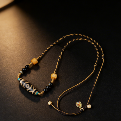 Handmade three eye dzi bead necklace with golden obsidian and amber main view