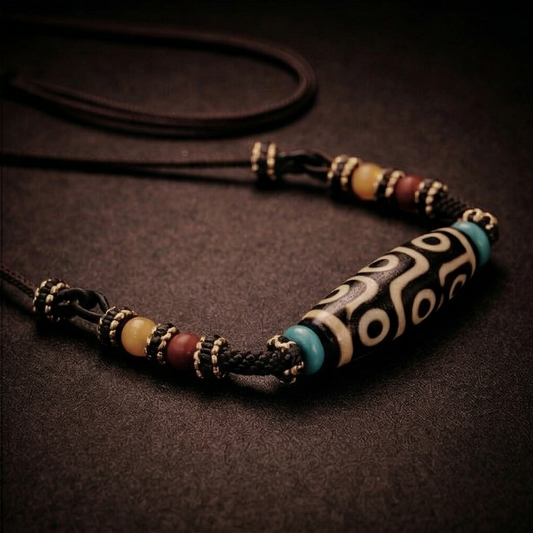 Full nine-eye Dzi bead necklace arranged on a dark surface