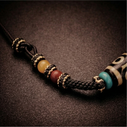 Braided cord and bead details of a nine-eye Dzi necklace