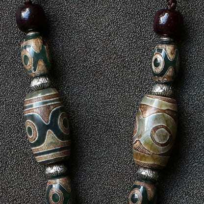 handcrafted Nepalese medicine eye Dzi bead necklace gray white cord and accessory detail