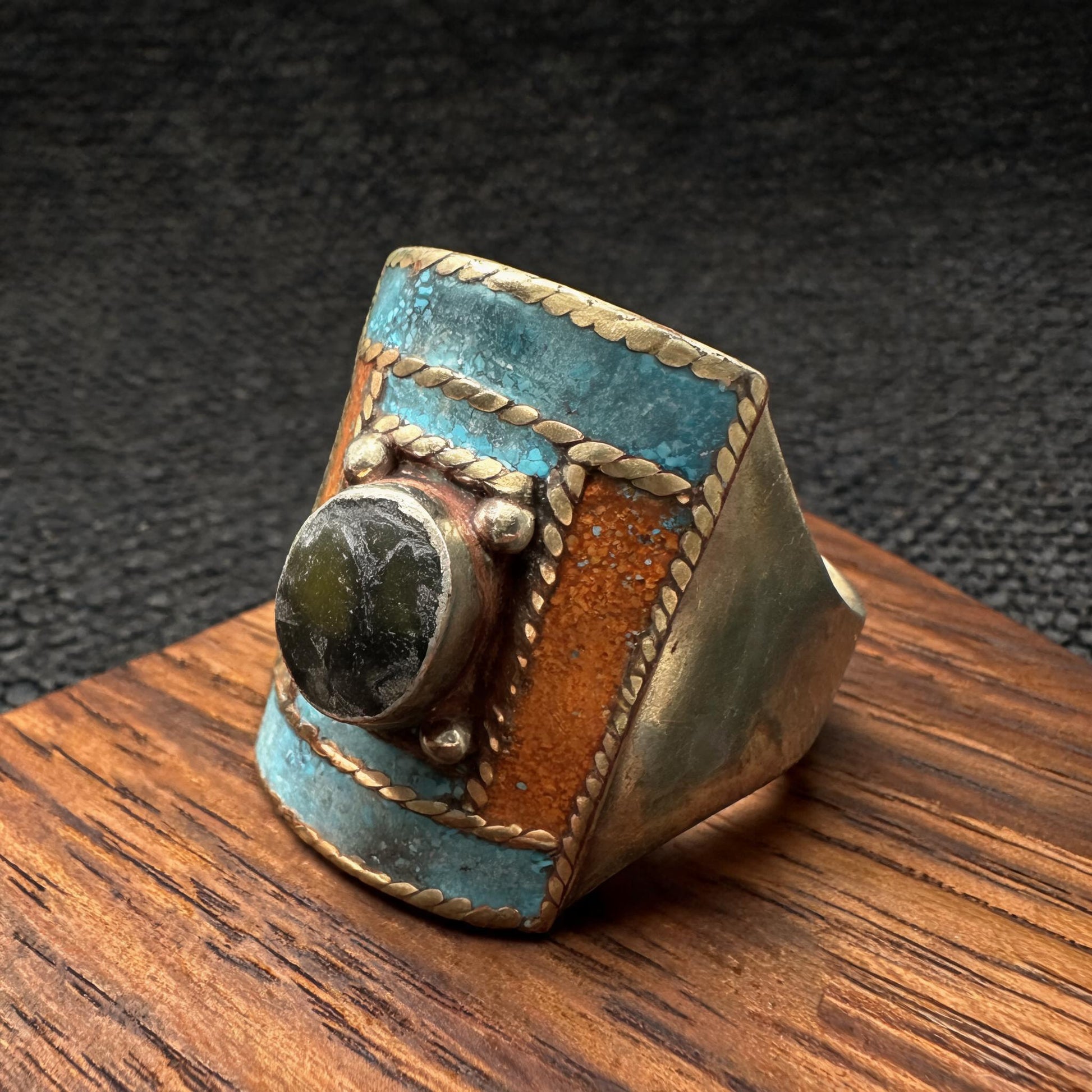 Hand-inlaid turquoise orange and dark stone statement ring front three-quarter view