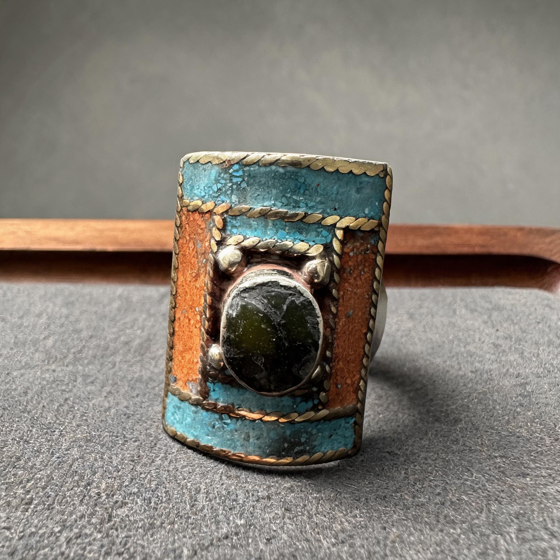 Hand-inlaid turquoise orange and dark stone statement ring straight front view