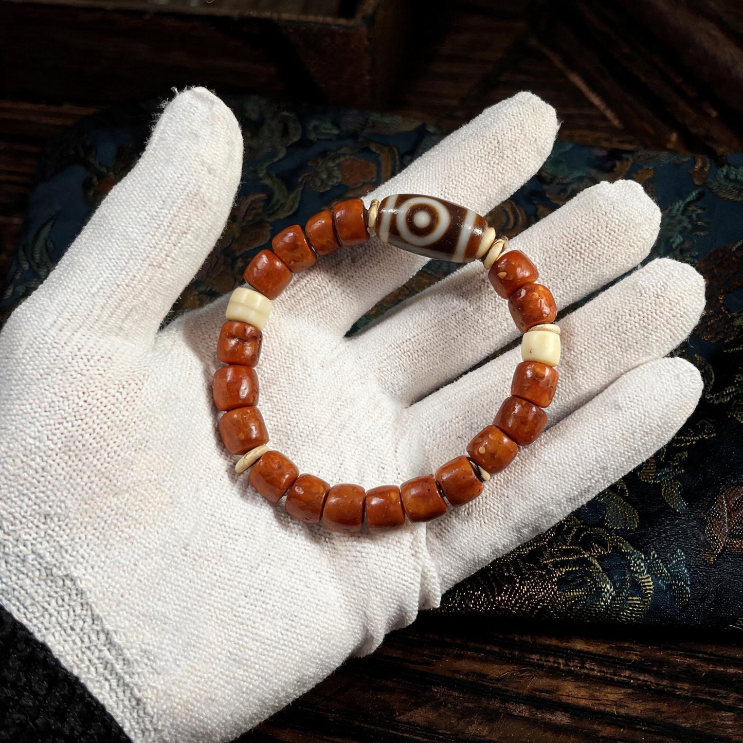 Dema Three-Eye Dzi and yak bone bracelet collector inspection