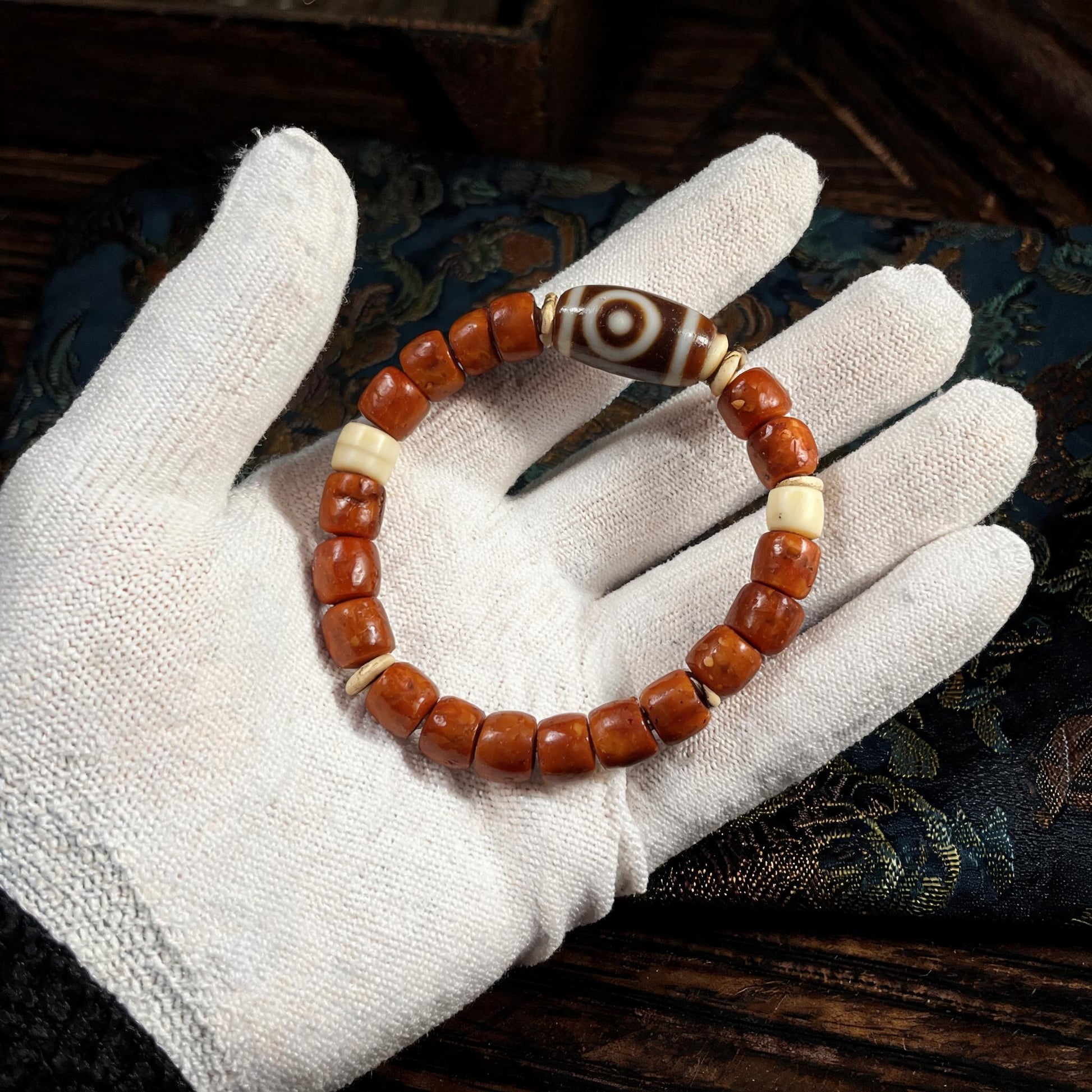 Dema Three-Eye Dzi and yak bone bracelet collector inspection