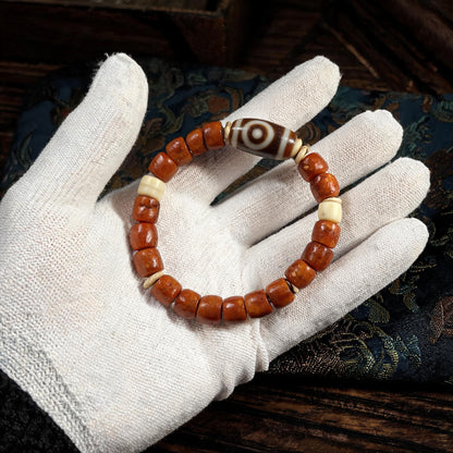 Dema Three-Eye Dzi and yak bone bracelet collector inspection