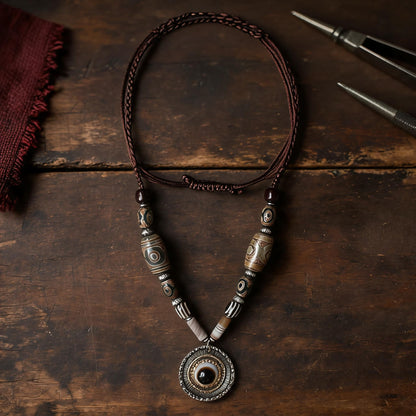 Handcrafted Nepalese Medicine Eye Dzi Bead Necklace in a warm artisan workshop setting