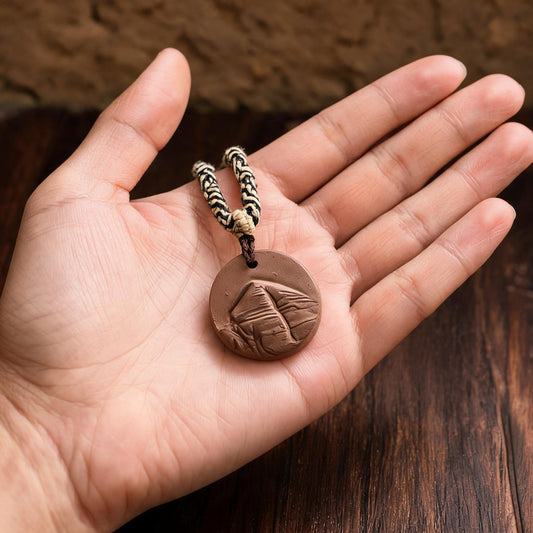 Mount Kailash Clay Tsatsa Pendant Necklace in an artisan workshop setting